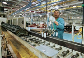 自動車工場内で労働者が作業しています。