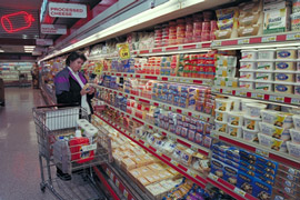 Woman in grocery store in front of dairy section