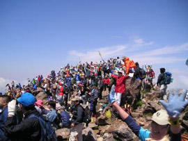 People cheering, standing on the top of a mountain