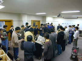 People standing around a table, eating and drinking