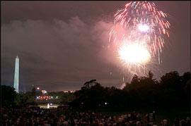 大きな花火が空に上がっており、ホワイトハウス前の広場にはたくさんの人々が集まっています。