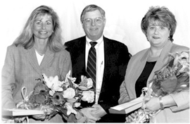花束を抱えた男性と２人の女性の写真です。