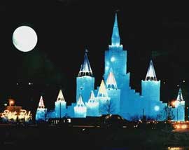 氷の城が青く光に浮かび上がり、その後方には大きな満月が出ています。