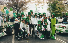 パレードに参加しているスケートクラブの若者達が、おそろいの緑の帽子をかぶり、記念撮影をしています。