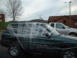 A car in parking lot wrapped in celophane.