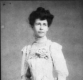 Photo of woman in white lace dress with high neck.