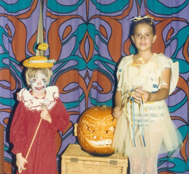 Boy and girl in costume, next to a jack-o-lantern