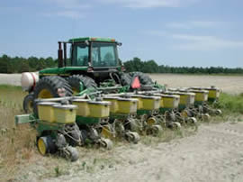 種蒔きため、大型トラクターの前部に取り付けられた播種機が並んでいます。