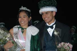 Boy and girl in formal clothes, wearing crowns.