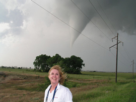 A woman poses in front of a tornado