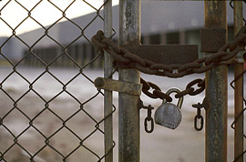 閉鎖された工場の敷地前、柵に鍵がかけられています。