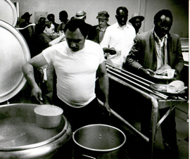 左に大きなお釜からスープをつぐ男性がいて、右にはそれを受け取る失業者の人たちの列ができています。